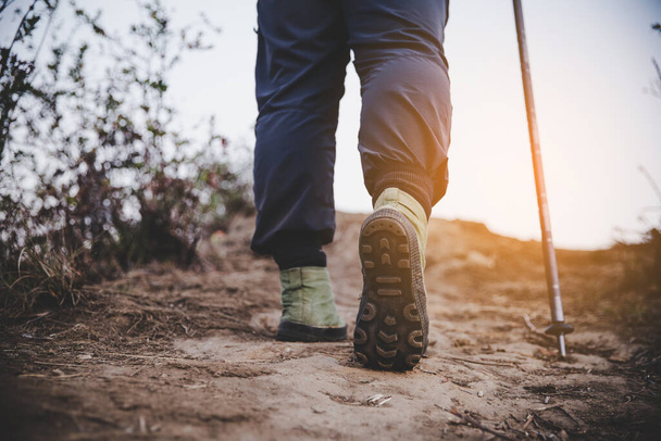 zapatos de senderismo en acción en un sendero desierto de montaña. Primer plano de los zapatos de excursionistas masculinos
. - Foto, Imagen