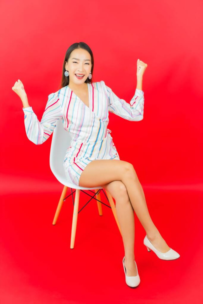 Portrait beautiful young asian woman smile with many action on red background - Фото, зображення