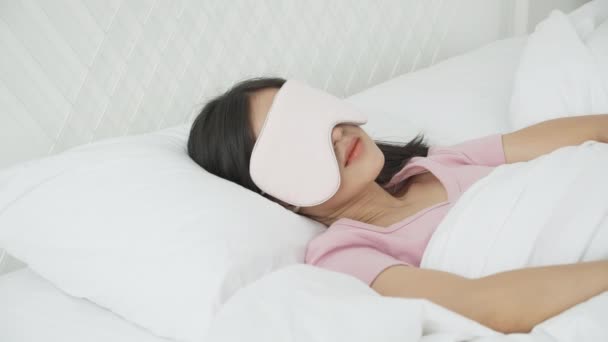 Piękna młoda azjatycka kobieta nosząca okładkę oka i śpiąca na łóżku z głową na poduszce komfort i szczęście w sypialni w domu, dziewczyna z relaksem i wypoczynkiem dla wellness, koncepcja stylu życia. - Materiał filmowy, wideo