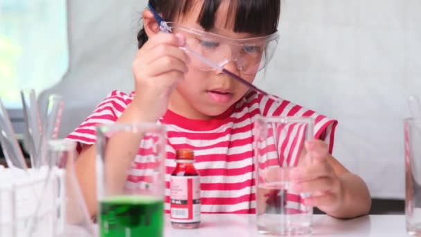 Kinder lernen und machen naturwissenschaftliche Experimente im Klassenzimmer. Kleines Mädchen spielt naturwissenschaftliches Experiment für den Schulbesuch zu Hause. Einfache und lustige naturwissenschaftliche Experimente für Kinder zu Hause. - Filmmaterial, Video