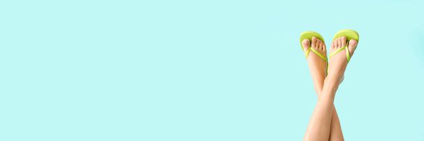 Jambes de jeune femme en tongs sur fond bleu clair avec espace pour le texte. Bannière pour le design - Photo, image
