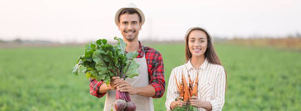Retrato de jóvenes agricultores con cosecha en el campo - Foto, imagen