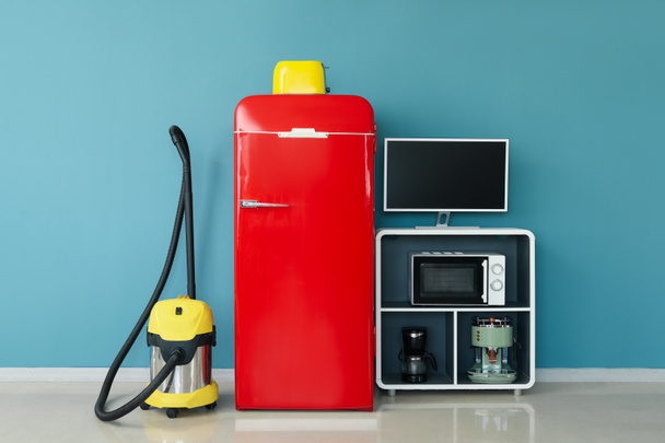 Modern household appliances near blue wall in room - Photo, Image