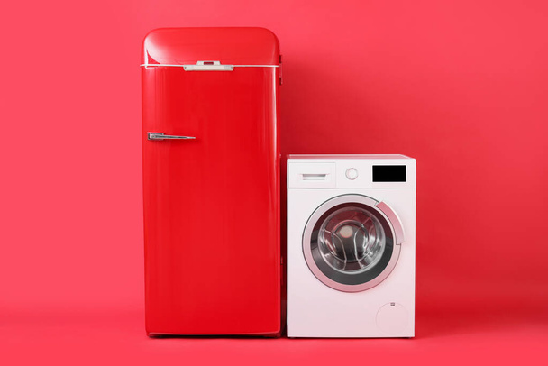 Stylish retro fridge and washing machine on red background - Photo, Image