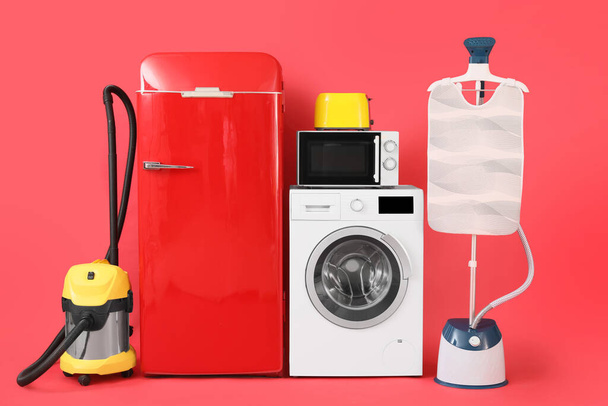 Modern household appliances on red background - Photo, Image