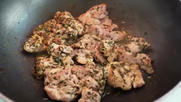 Trage bakkip in Provence kruiden, pittige saus, hete olie in koekenpan, close-up. Spaanse keuken, Kinderkip - Video