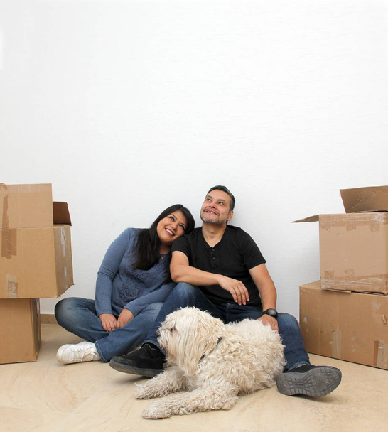 Couple of Latin man and woman move house thanks to a real estate agency they are happy for the beginning of a new life together and create a family - 写真・画像