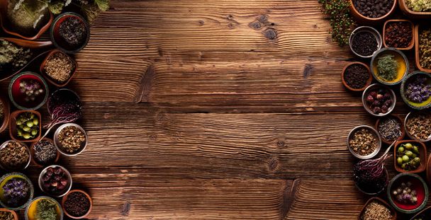  Médecine naturelle. Assortiment d'herbes sèches dans des bols et mortier en laiton sur une table en bois rustique. - Photo, image