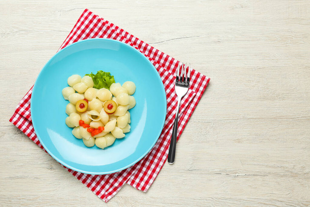 Tasty pasta served on wooden table, flat lay. Creative idea for kid lunch - Foto, afbeelding