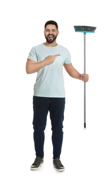 Young man with broom on white background - Foto, imagen