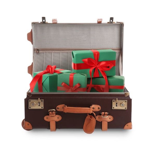 Beautiful green gift boxes with red bows in retro suitcase on white background - Foto, afbeelding