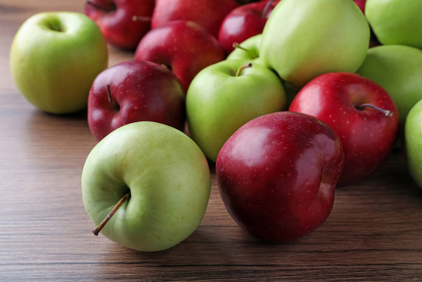 Čerstvě zralá červená a zelená jablka na dřevěném stole, detailní záběr - Fotografie, Obrázek