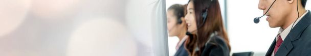 Οι επιχειρηματίες που φορούν ακουστικά που εργάζονται στο γραφείο διευρύνουν την προοπτική υποστήριξης απομακρυσμένου πελάτη ή συναδέλφου. Τηλεφωνικό κέντρο, τηλεμάρκετινγκ, πράκτορας υποστήριξης πελατών παρέχουν την υπηρεσία στην τηλεφωνική κλήση βίντεο. - Φωτογραφία, εικόνα