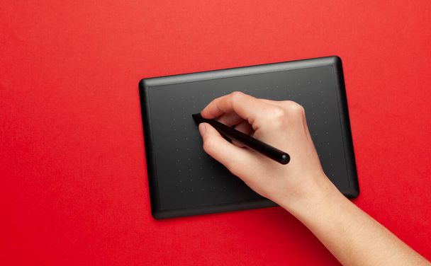 Graphic tablet for drawing and designer hand on red background. Creative art, sketch. - Zdjęcie, obraz