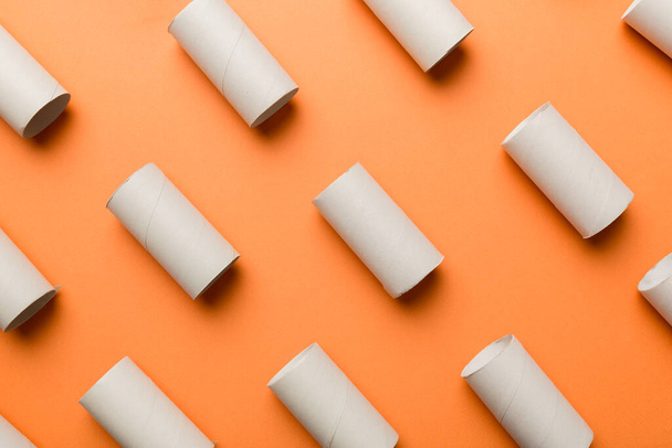 Rollo de papel higiénico vacío sobre fondo de color. Tubo de papel reciclable con extremo de tapón metálico hecho de papel kraft o cartón. - Foto, imagen