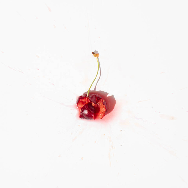 Squashed red cherry berry fruit on bright white background. Red ripe fruit concept. Healthy food idea. - 写真・画像