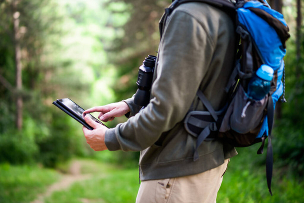 Image of hiker using digital tablet while spending time in nature. - Fotó, kép