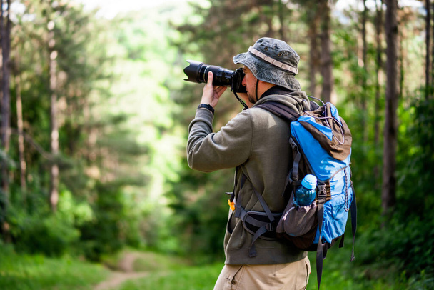 Image of man photographing  while hiking in the nature. - Foto, afbeelding
