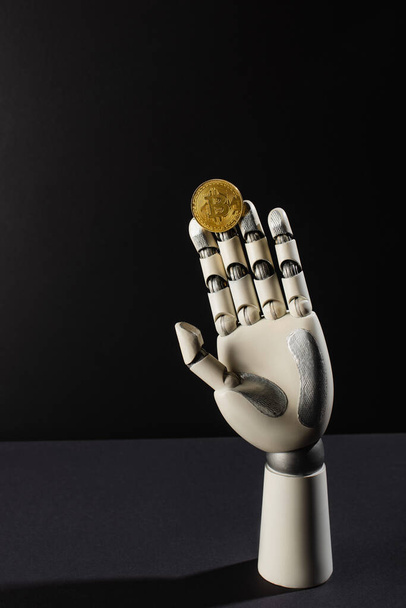 QUIIV, UCRÂNIA - 26 de abril de 2022: Bitcoin e mão robótica sobre fundo preto - Foto, Imagem