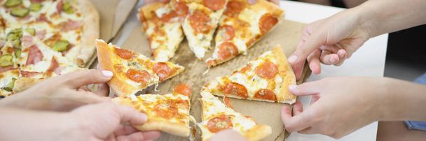 Zbliżenie ludzi ręce dużej firmy wziąć kawałek. Gorąco pachnąca pizza z pomidorami i serem, zamówić pizzę jako przekąskę. Fast food, jedzenie na wynos, jedzenie, głód, impreza, obiad, pomysł na wakacje - Zdjęcie, obraz