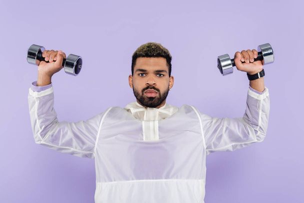 young african american man exercising with dumbbells isolated on purple  - Φωτογραφία, εικόνα