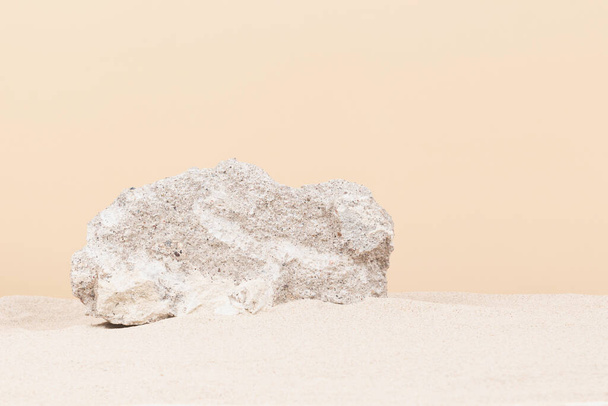 Grungy grey concrete stone platform podium for cosmetics or products on white beach sand background. Front view. - 写真・画像
