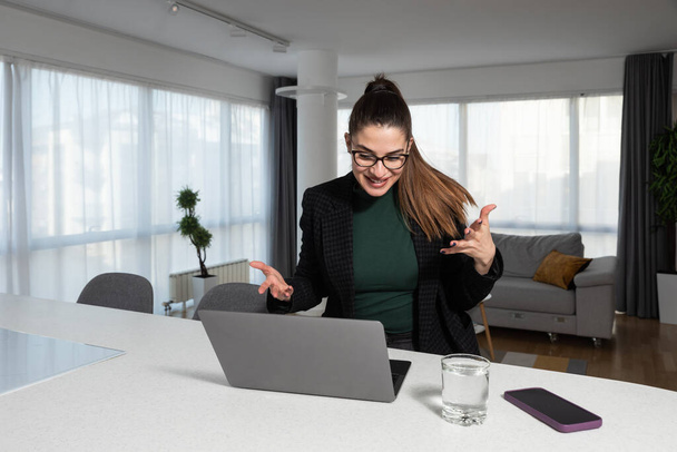 Онлайн-конференция. Умная деловая женщина, использующая ноутбук для видеозвонка деловому партнеру. Домашний офис. Умная женщина-эксперт, работающая из дома за компьютером для телекоммуникации. - Фото, изображение