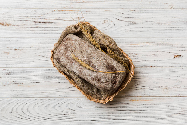 Frisch gebackenes Brot auf Korb vor natürlichem Hintergrund. Brotkopierplatz von oben. - Foto, Bild