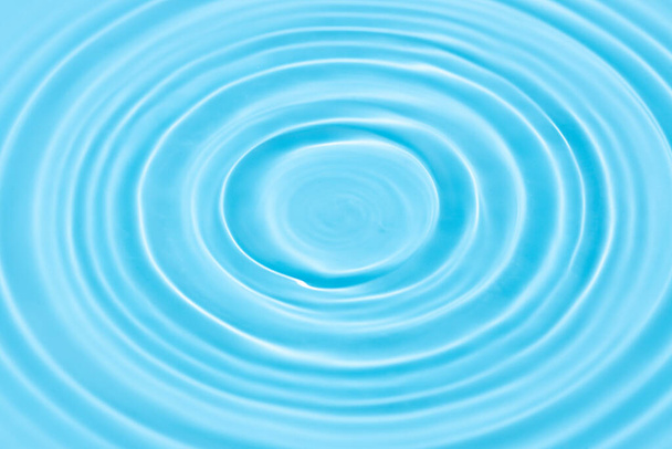 Фон голубой воды текстура с кругами капель на поверхности воды - Фото, изображение