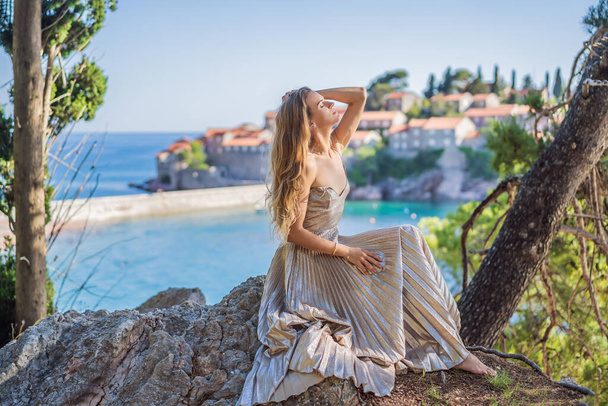 Woman tourist on background of beautiful view of the island of St. Stephen, Sveti Stefan on the Budva Riviera, Budva, Montenegro. Travel to Montenegro concept. - Φωτογραφία, εικόνα