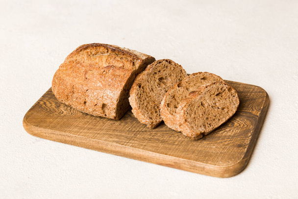 Auswahl an frisch geschnittenem Brot mit Serviette auf rustikaler Tischplatte. Gesundes ungesäuertes Brot. Französische Brotscheibe. - Foto, Bild