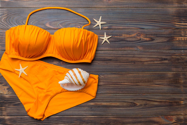 Kadın mayo ve plaj aksesuarları renkli arka plan yaz seyahati konseptine düz bir görünüm kazandırıyordu. Bikini mayo, hasır şapka ve deniz topuklu ayakkabı. Üst görünümü kopyala. - Fotoğraf, Görsel