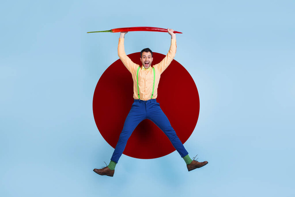 Creative artwork template of active guy levitating hold red chili pepper cook meal flavor isolated colorful background. - 写真・画像