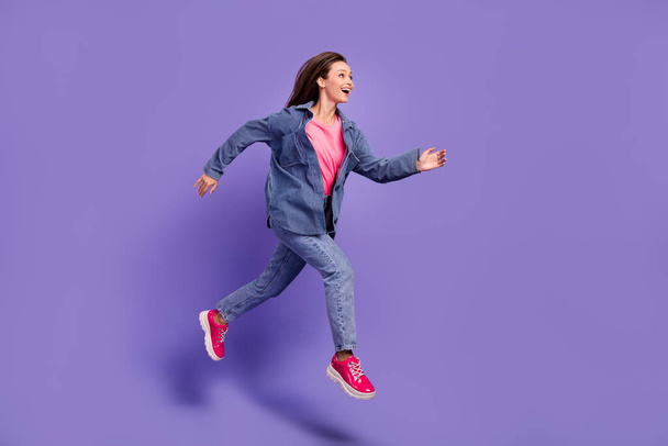 Full body photo of excited overjoyed person look empty space jump hurry fast isolated on violet color background. - Fotografie, Obrázek