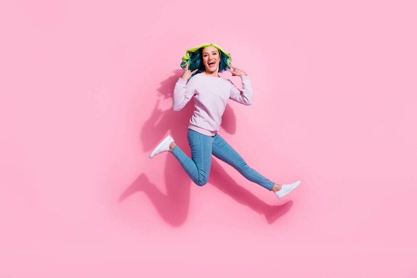Full size portrait of careless excited person jumping arms fingers demonstrate heavy metal symbol isolated on pink color background. - Foto, Imagen
