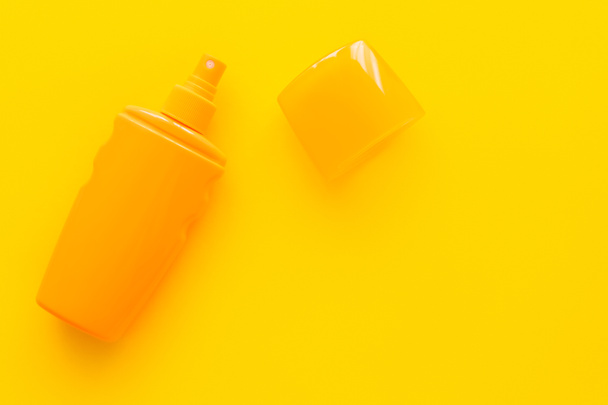 Top view of sunscreen with cup on yellow background  - Foto, immagini