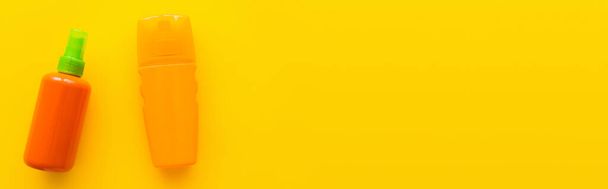 Top näkymä aurinkovoidetta pulloissa keltaisella pohjalla, banneri  - Valokuva, kuva