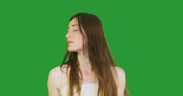 A young long-haired woman shakes her head from side to side, enjoying the wind blowing through her hair. The girl enjoys the moment. Green screen, chroma key, portrait, close-up. High quality 4k - Footage, Video