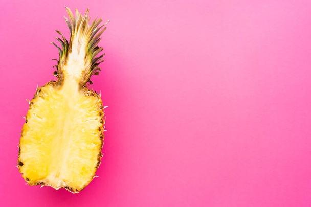 Top view of cut pineapple on pink surface - Фото, зображення