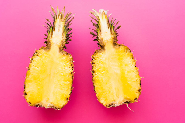 Top view of ripe pineapple on pink surface - 写真・画像