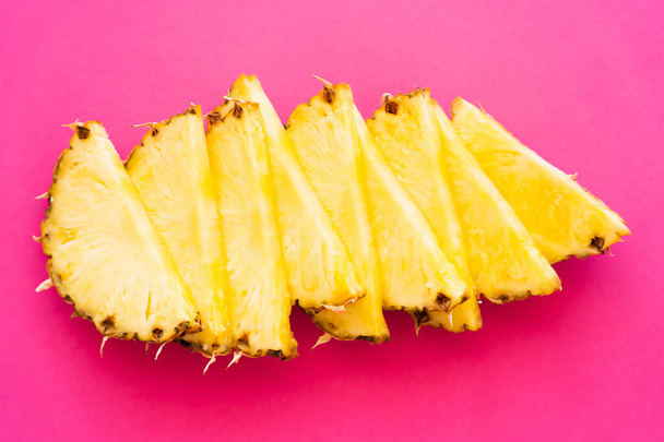 Top view of ripe pineapple on pink surface - Foto, Imagen
