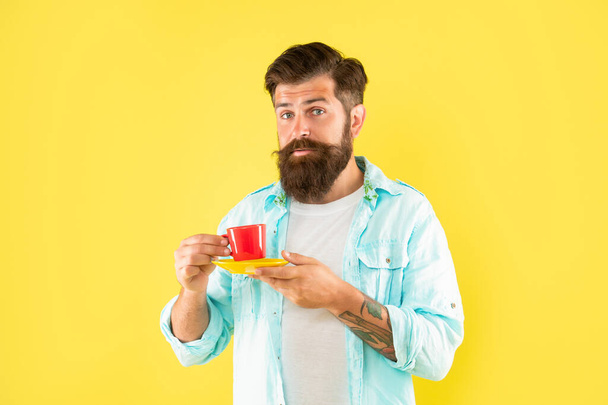 unshaven man in shirt with coffee on yellow backdrop, coffee cup. - Foto, immagini