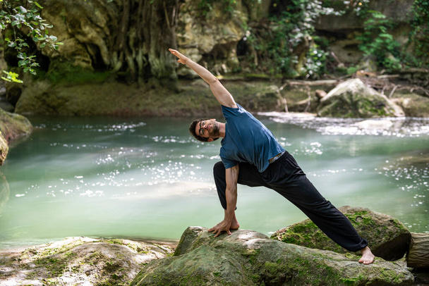 хлопчик робить йогу на річці, одягненій вдень
 - Фото, зображення
