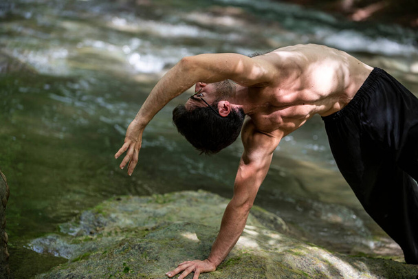ragazzo che fa yoga senza sella sul fiume in estate - Foto, immagini