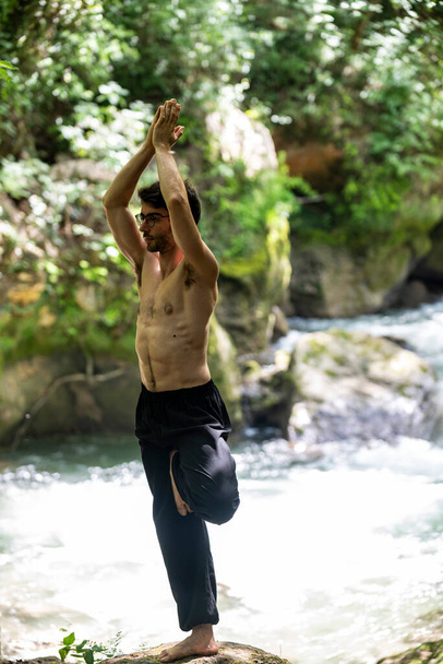 kaveri tekee paljain selin joogaa joella kesällä - Valokuva, kuva