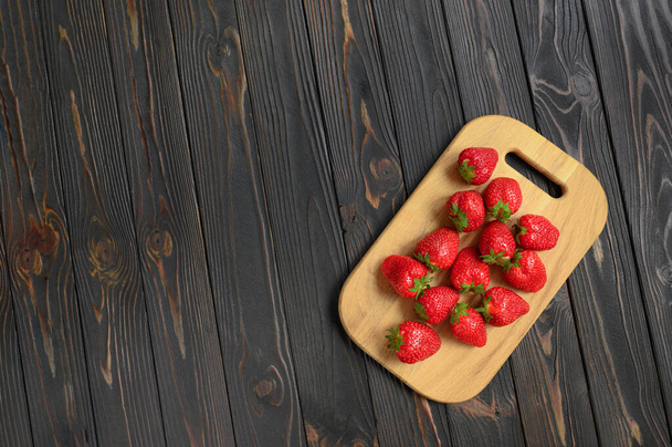 Fraises rouges juteuses sur une table rustique en bois. Le concept de collations saines et diététiques. - Photo, image