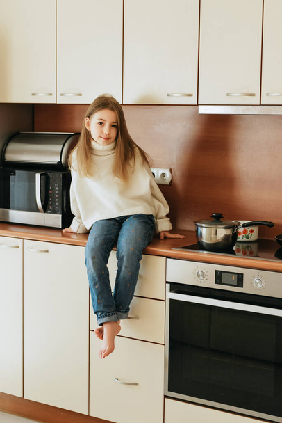 fille 9 ans avec des cheveux longs modèle écolière à la maison style de vie sur un fond beige  - Photo, image