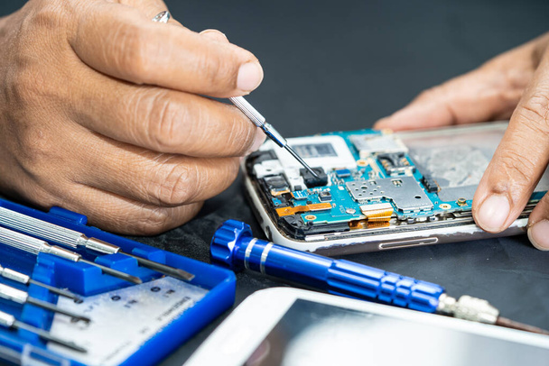 Technician repairing inside of mobile phone by soldering iron. Integrated Circuit. the concept of data, hardware, technology. - Photo, Image