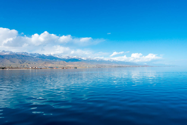 Sverny shore of Lake Issyk-Kul, Kyrgyzstan. View from the ship to the shore. Blue water of a mountain lake. Natural landscape. - Fotografie, Obrázek