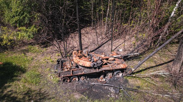 The war in Ukraine, destroyed tank, destroyed tank near the road in the woods, side view, aerial view - Photo, Image